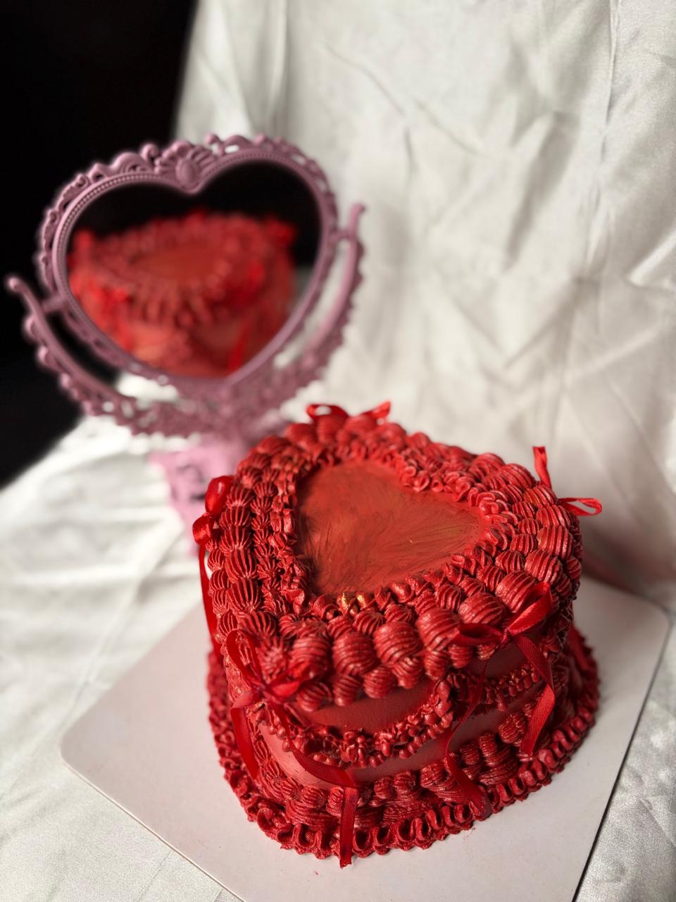 Heart-shaped red velvet cake with piping and mirror